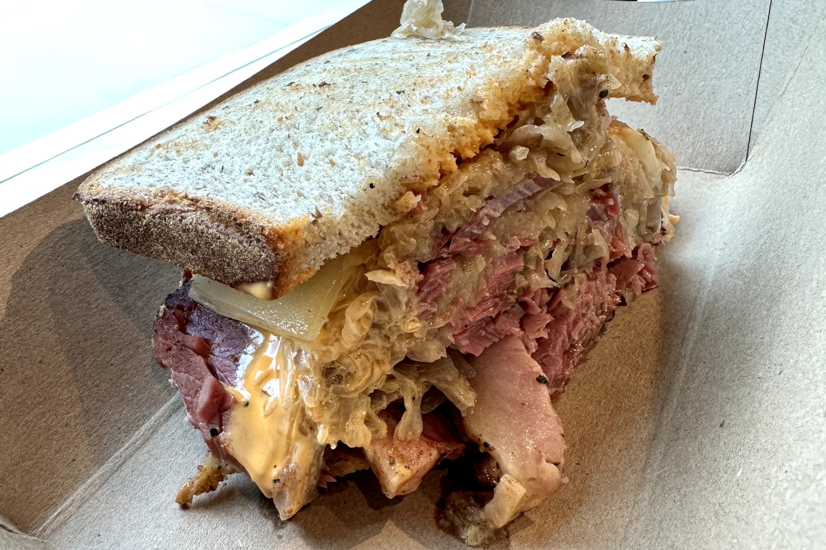 A pastrami sandwich with sauerkraut sitting by a window at Gambill's Jewish Deli in Tulsa, Oklahoma.