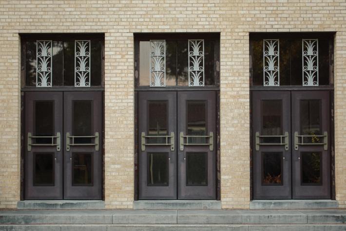 Three sets of doors displaying art deco details at Daniel Webster High School