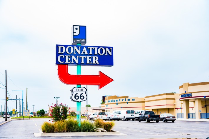 Blue sign reading "Donation Center" sign and red arrow sign pointing towards a building.