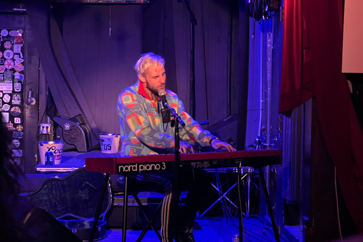 Robert Ellis plays piano under blue lights at Mercury Lounge.